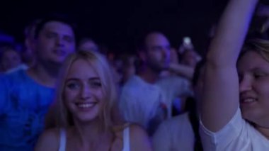 2021-08-07 - Mariupol Şehir Festivali, Ukrayna. Hayranlar el sallıyor, konserin tadını çıkarıyor. Gece müzik festivalinde heyecanlı seyirci dansı. Işıklar gülen yüzlere parlıyor, yaz etkinliklerinde neşeli bir grup..