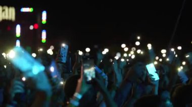 2021-08-08 - Mariupol Şehir Festivali, Ukrayna. Taraftarlar sahneye çıkıp yaz eğlencelerini kutluyorlar. Aydınlatılmış telefonlu kalabalık açık hava müzik festivalinde geceyi aydınlatıyor..