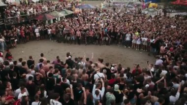 2021-08-08 - Mariupol Şehir Festivali, Ukrayna. Hava manzaralı enerjik kalabalık açık hava müzik festivalinde ölüm duvarı oluşturuyor. Rock hayranları yüksek adrenalinle öne fırlıyor. Metal konserindeki insanlar.