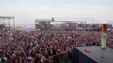 2021-08-08 - Mariupol Şehir Festivali, Ukrayna. Grup sahnede canlı performans sergiliyor, hayranlar konserin, yaz festivali atmosferinin tadını çıkarıyor. Açık hava müzik festivalindeki enerjik kalabalık çember içinde dans ediyor.