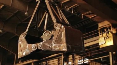 Makineleri operatör kontrol ediyor, atölye çalışıyor. Endüstriyel fabrikada vinç ağır metal kaldırıyor. Çelik üretimi, ağır sanayi, mühendislik, imalat, ekipman kullanımı, işçi.