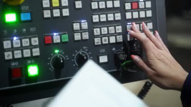 Metal işlerinde uzman, makine parametrelerini üretim için ayarlıyor, endüstriyel sektörde çalışıyor. Becerikli kadın makinist CNC dinleme merkezini hassasiyetle çalıştırıyor, üretim süreci için kontroller kuruyor.