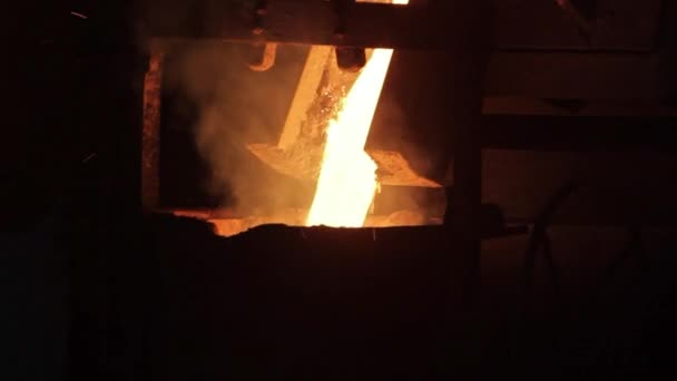 金属铸造工艺在生产厂 炉中闪烁着炽热的橙色光芒 铸造工业用钢液浇注 工人操作冶炼设备 重工业生产 — 图库视频影像