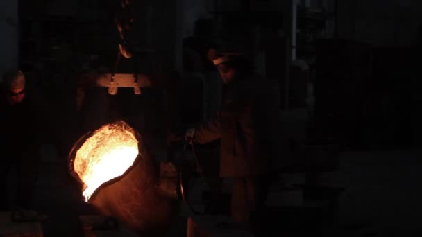 チームは工場で鋼鉄鋳造を行い 重い機械類を扱います 工業労働者は鋳造物に溶融した金属を注ぐ 手動労働 高温操作 研修会の金属加工プロセス — ストック動画