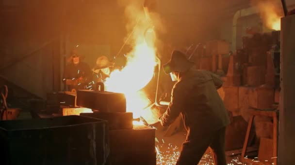 강철을 취급하고 불꽃은 공장에서 날아갑니다 장치에 노동자는 선반에 용융된 금속을 — 비디오