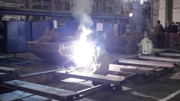 精密金属加工 在车间制造钢结构 工业工人穿着防护服 在工厂里焊接铁梁 喷出火花 熟练工艺 安全措施 — 图库视频影像