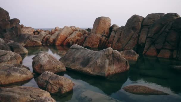 浪花轻轻拍打着石边 引来了冒险 天然水池中晶莹清澈的水 栖息在崎岖的岩石中 平静的海滨景致招手 关于健康务虚会 记录片 慢动作 — 图库视频影像