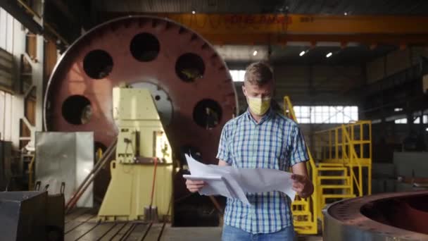 Maskeli Erkek Profesyonel Tasarım Belgelerini Inceliyor Mühendis Sanayi Atölyesindeki Makinelerin — Stok video
