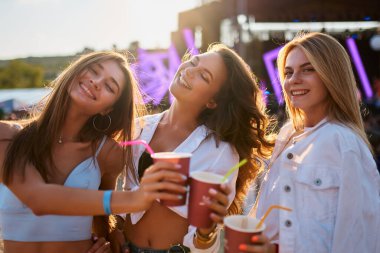 Yaz kıyafetleri içinde gülen arkadaşlar açık hava konserinin, gün batımının tadını çıkarırlar. Plaj müzik festivalinde kadınlar içkiyle tezahürat yapar. Grup kutlamaları, kokteyllerle kadeh kaldırmalar, kaynaşma, günlük ortamlarda kahkahalar..