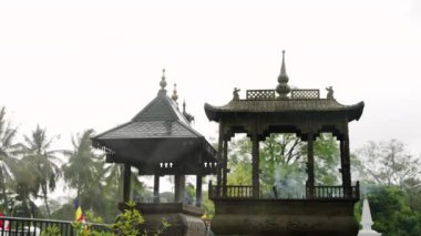 Sri Dalada Maligawa, Kandy 'de ruhani ayin. Budist tapınağındaki süslü ocaktan tütsü kokusu yayılıyor. Yavaş çekim, dingin, yeşil ortamda kutsal atmosferi yakalar. Yavaşla