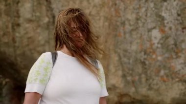 Aktif yaşlı yürüyüşçü seyahat eder, doğayı sever, dağ macerasında gençlik ruhunu somutlaştırır. Sırt çantalı Asyalı yaşlı kadın kayalık araziyi keşfediyor, antik Sigirya Kayası manzarasına hayran. Yavaş çekim.