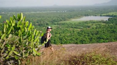 Sırt çantalı maceraperest sakin doğanın tadını çıkarıyor, eko-turizm uyguluyor. Kadınlar kayalık arazide yürüyüş yapar, Pidurangala Kayası 'nın geniş manzarası vardır. Yürüyüşçü huzuru, ıssızlığı ve ıssızlığı bulur..