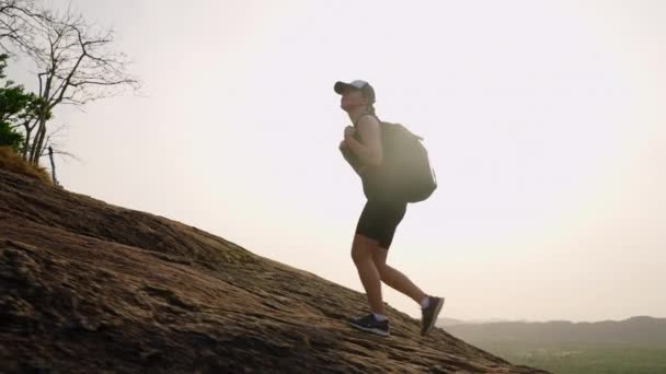 モーニングクライミングは 豊かな景色 フィットネスアドベンチャーでモチベーションを刺激します アクティブな女性ハイカーは日の出に急な山道を登り 持続性 強さを示しています ピッド ジャマラ ロック — ストック動画