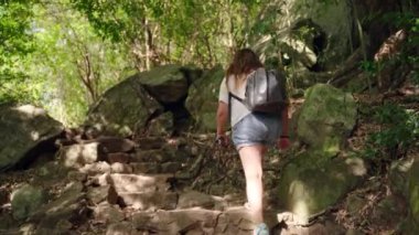 Kıdemli doğa yürüyüşçüsü, orman patikalarını keşfediyor. Sırt çantalı yaşlı kadın engebeli dağ yolunda yürüyor. Macera seyahati, zorlu araziyi aşan yaşlı kadın tırmanışçıların sağlıklı yaşam tarzı. Yavaşla