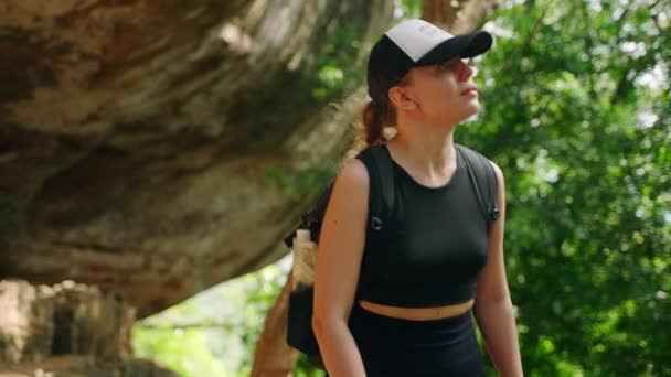 在大自然中冒险 促进可持续的户外活动 活跃的女人在岩洞附近的岩石地形中爬行 用折叠的生态瓶子中的水浇灌 旅行者探索 — 图库视频影像