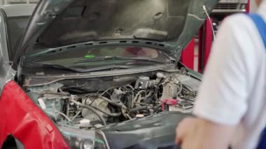 Otomatik mekanik, garajdaki motor bloğuna kompresör aleti kullanarak piston halkaları kurar, araba tamirini, atölye çalışmasını, araç bakımını, DIY görev motoru montaj becerilerini gösterir.