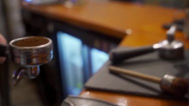 Sabah kahvesi hazırlama ritüeli, profesyonel ekipmanlar iş başında. Becerikli kahve ustası, şehirdeki kafe reyonundaki portafilterde taze espresso yapıyor. Kusursuz çıkartma için kesinlik tamlaması.