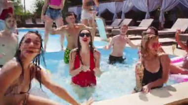 Erkekler ve kadınlar yüzme havuzunda temiz mavi su ve şişme tüplerle dans, güneş banyosu, yüzme ve kutlama partilerinde. Zayıf vücutlar, büyüleyici gülümsemeler, yüksek sesli kahkahalar ve mankenlerin güzel yüz ifadeleri..