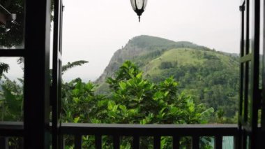 Ön planda balkon rayı, sakin Sri Lanka manzarası, seyahat yeri. Açık terastan bakıldığında, zengin bitkiler manzaralı Ella Kayası 'nı çevrelemektedir. İnsanlar yok, huzurlu bir geri çekilme, doğa güzelliği. Yavaş çekim.