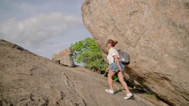 Yaşlı yürüyüşçü Pidurangala Kayası 'nı fetheder, sabah yürüyüşünde gücünü gösterir. Asyalı son sınıf öğrencisi kadın sırt çantasıyla dik dağ yoluna tırmanıyor. Zirveye ulaşır, azmi, doğadaki motivasyonu sembolize eder..
