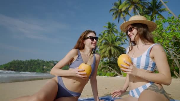 Две Счастливые Девушки Тост Приветствуют Кокосовые Коктейли Песчаном Пляже Райском — стоковое видео