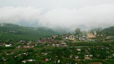 Manzaralı tren yolculuğu yeşil yamaçlar, ikonik yolda köy hayatı. Haputale dağlık arazisinde dolanan İHA treni, bulutlu Sri Lanka 'daki çay tarlalarıyla çevrili..