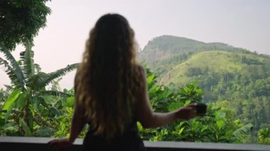 Tatil gezisi, Sri Lanka 'da sakin bir manzara. Kadınlar tatil köyü terasında kahveyi sever, zengin Ella Rock dağ manzarası ileride. Rahatlama, lüks yaşam tarzı kadın egzotik ortamların ve sükunetin tadını çıkarırken birleşti..