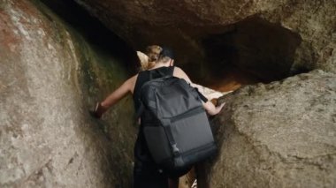 Sırt çantalı yalnız gezgin engebeli araziyi keşfeder, vahşi yolları aşar. Maceracı kadın yürüyüşçü dar dağ geçidinde geziniyor, tepesinde kayalar var. Doğa aşıkları macerası, açık hava mücadelesi. Yavaşla