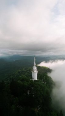 Yeşil çevre yapısı, sakin bir manzara yaratıyor. Sri Lanka 'daki Ambuluwawa Kulesi' nin İHA 'sı dağ zirvesinde bulutların üzerinde yükseliyor. Ziyaretçiler keşfederler, doğaya dalarlar güzellik, seyahat yerleri.