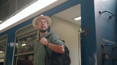 Macera peşinde koşan kişi sırt çantası taşıyor. Asyalı erkek gezgin trenden iniyor, istasyon platformunu keşfediyor. Tren yolculuğu, turist vagonu, şehir keşfi başlıyor. Yaz, gezgin şehvet, geçiş.