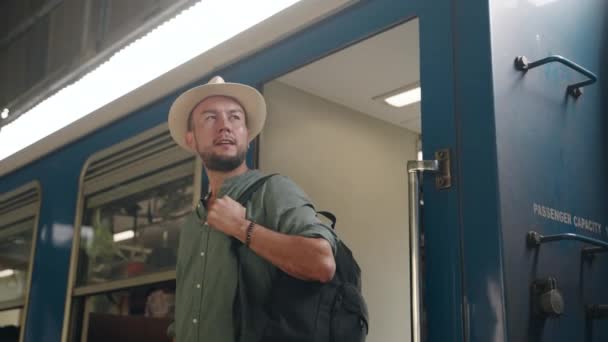 Adventure Seeker Wears Carries Backpack Asian Male Traveler Steps Train — стоковое видео