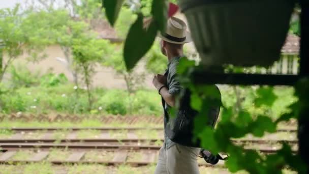 人类探索斯里兰卡的文化 戴帽子 背着背包 亚洲男性游客带着相机沿着Haputale火车站步行 独行探险 享受异国情调的旅行风景 — 图库视频影像