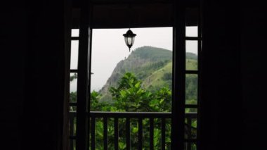 Hill Country villasından manzara manzarası. Ella Rock manzaralı, bitkilerle dolu bir terastan. Sri Lanka 'daki panoramik dağ manzarası lüks bir mülkten. Rahatlamak ve seyahat etmek için huzurlu doğal ortam.