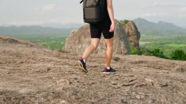 Solo gezgin Sri Lanka manzarasını keşfediyor. Aktif kadın yürüyüşçü, zengin yeşil manzaralı Sigiriya Kayası arka planına sahip dağ yolundan iniyor. Maceralı yürüyüş, eko turizm, açık hava fitness yaşam tarzı.
