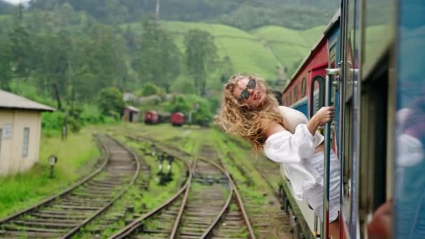 Кудрявая Женщина Солнечных Очках Наслаждается Живописным Железнодорожным Путешествием Чувствует Ветер — стоковое видео