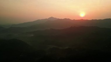 Sis, ağaçların tepelerinden süzülüp huzur verici bir manzara yaratıyor. Gün ışığı Sri Lanka 'da tepeleri, vadileri öperken şafak söker Ella dağlarını. Seyahat, doğa meraklıları gökyüzünden nefes kesici manzaralara tanıklık eder..