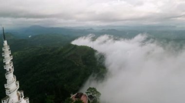 Sabah sisi dalgalı dağlık araziye karşı esrarengiz bir hava katıyor. Hava aracı sisli Ambuluwawa Kulesi 'ni süpürerek Sri Lanka dağlarının tepesindeki zengin yeşil bitkileri ortaya çıkarıyor..