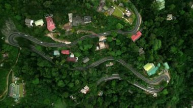 Arabalar dar virajlarda, kırsal ulaşımlarda tropikal manzaralarda yol alırlar. Sri Lanka 'daki yeşil ormandan geçen dağ yollarının hava manzarası. Manzara güzergahı hareketli topluluk renkli evler.