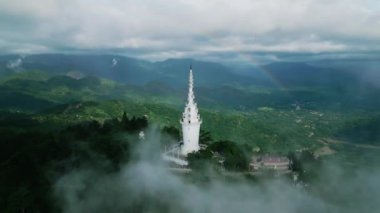 Manzaralı seyahat manzarası, bulutlu gökyüzünün altında canlı yeşil manzaralar, nefes kesici manzaralar sunuyor. İnsansız hava aracı Ambuluwawa Kulesi 'nin üzerinden uçarak sisli Sri Lanka dağlarındaki gökkuşağını ortaya çıkarıyor. Havadan