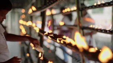 2023-06-01 - Kandy, Sri Lanka. Sri Dalada Maligawa Budist Tapınağı. Geleneksel alev sunma töreni, inançlı dindarlar. Bireysel ışıklar arka arkaya gaz lambaları, tapınakta ruh ayini..