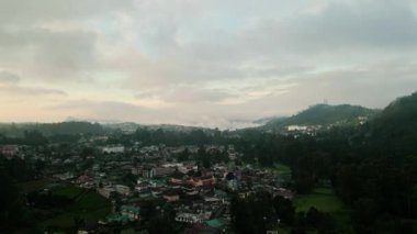 Gündoğumu Nuwara Eliya 'yı yumuşak, havadan seyrediyor Seylan çay tarlaları, sakin şehir Sri Lanka dağları üzerinde gün doğarken sisli tepelerin arasında uyanıyor, sükuneti ve doğal güzelliği davet ediyor..