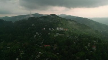 Alacakaranlık ışığı yumuşar, dron ormanın üzerinde süzülür, huzur veren güzelliği yakalar, doğa günün sonunda sakinleşir. Sri Lanka 'daki Ella dağlarının üzerinde günbatımı perdeleri, zengin yeşil tepelerin arasında bukleler.