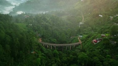 Tropikal ormanlar arasındaki tarihi demiryolu, ikonik seyahat noktası. Sri Lanka 'daki Nine Arch Köprüsü' nün hava gündoğumu manzarası zengin yeşilliklerle çevrili, sis. Sabahın ilk ışıkları manzarayı yıkıyor..