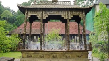 Duman havayı dolduruyor, dinsel siteye ortam katıyor. Antik Budist tapınağında tütsü çubukları süslü sunakta yanar, Kandy. Ağır çekimde görülen ruhani uygulamalar sükuneti vurgular. Yavaşla