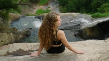 Yalnız gezgin doğayı sever, manzarada yalnızlığı sever. Uzun kıvırcık saçlı kadın uçurumun kenarında oturur ve şelaleye bakar. Sular çağlayarak meditasyon yapan kişi, huzur ve açık havada farkındalık bulur..