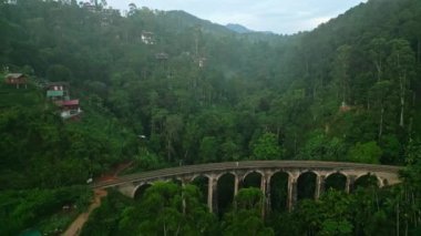 Solo gezginler, yemyeşil ormanlarla çevrili tarihi demiryollarında yürürler. Drone, Sri Lanka 'da güneş doğarken Nine Arch Köprüsü' ne çıkıyor. İkonik kemerler yeşil manzaranın arasında miras sembolü olarak duruyor.