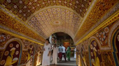 2023-06-01 - Kandy, Sri Lanka. Duvar resimleri, oymalar antik Budist tapınak duvarları hacılar ruhanilikle uğraşır. Beyazlı fanatikler Sri Dalada Maligawa, Kandy 'nin süslü koridorunda yürüyorlar..