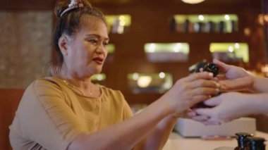 Asyalı emekli kadın cam şişeden el yapımı aroma yağı kokusu alıyor. Çift ırklı son sınıf dişileri otantik spa merkezinde ayuverdik ilaç kokusundan hoşlanırlar. Çok ırklı yetişkinler spa losyonunun kokusunu soluyor.