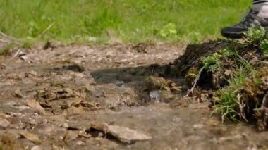 Turist kadın, dağ deresinden çevre dostu şişelere temiz su topluyor. Açık havada yürüyüş hidrasyonu. Vahşi doğada taze içme suyu koleksiyonu. Sürdürülebilir çevre dostu seyahat ekipmanları.