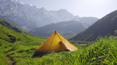 Kadın çadırda uyanıyor, esniyor, dağ manzarasına çıkıyor. Svaneti 'de tek başına gezen, Jangi-Tau Vadisi' nde sabahları temiz hava soluyor. Aktif yaşam tarzı, macera çevre dostu turizm. Yavaşla